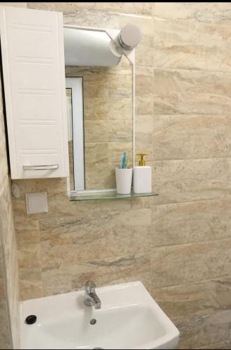a bathroom with a sink and a mirror at Shaterovi Gerbera Panoram in Plovdiv