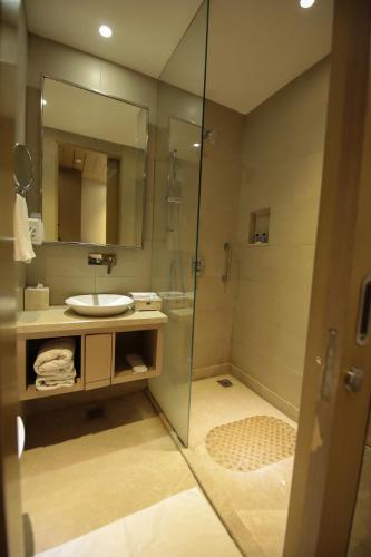 a bathroom with a sink and a shower with a mirror at Days Hotel Jaipur Tonk Road By Wyndham in Jaipur