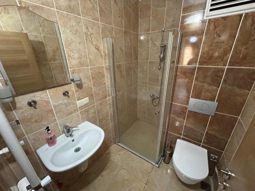 a bathroom with a shower and a sink and a toilet at Borahan Hotel in Trabzon