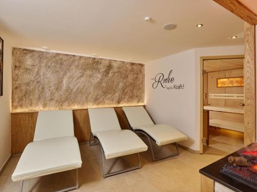 a waiting room with white chairs and a table at Fremdenpension Alpenruhe in Sölden