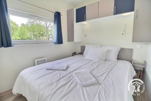 a bedroom with a large white bed with a window at TI WAR AN DOUR in Guégon