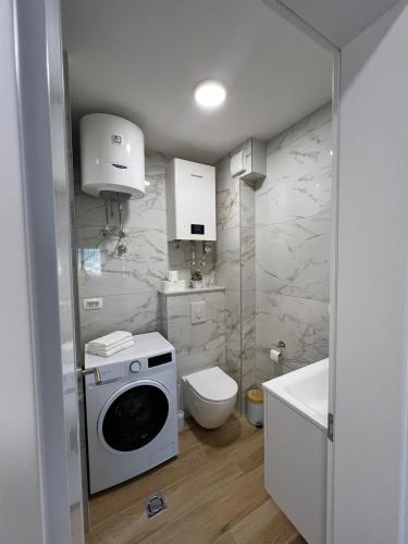 a bathroom with a washing machine and a toilet at Ana in Posušje