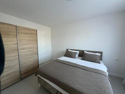 a bedroom with a large bed and a wooden cabinet at Ana in Posušje