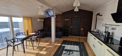 a kitchen and living room with a table and chairs at Scandidim Lutsk in Lutsk