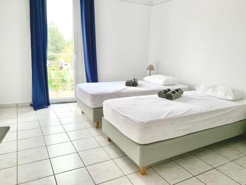 two beds in a room with a window at Hayeks Villa private pool near the beach in Daratso