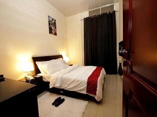 a bedroom with a bed and a desk and a bed sidx sidx sidx at St Augustine Apart & Hotel in Kigali