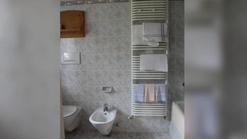 a bathroom with a sink and a toilet and towels at Garni Villa Linda in Corvara in Badia