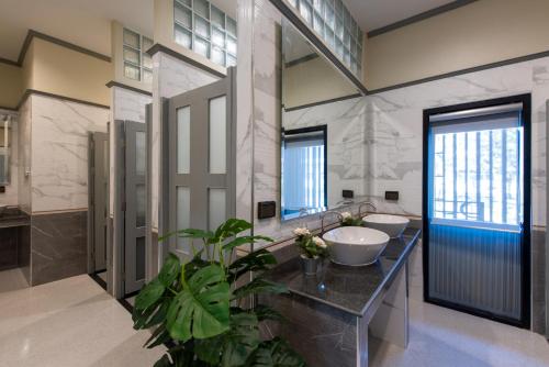 a bathroom with two sinks and a large mirror at Peya Rama-7 Hotel in Bang O