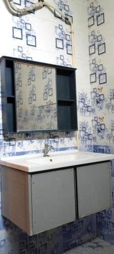 a bathroom with a sink and a mirror on a wall at Moonlight Resorts Idappadi in Ammāpettai