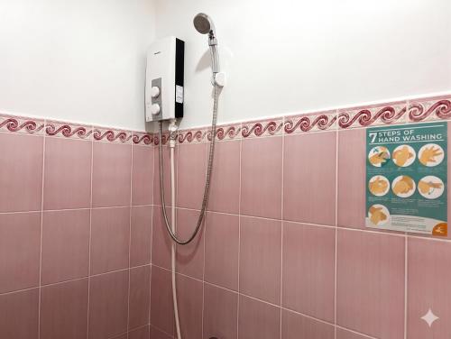 a shower in a bathroom with pink tiles at RedDoorz @ Greenview Hotel and Restobar Masbate in Masbate