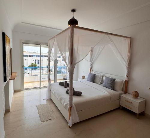 a bedroom with a white bed with a canopy at Perle Bleue de Gammarth in Gammarth