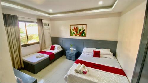 a bedroom with two beds and a window at RedDoorz @ Greenview Hotel and Restobar Masbate in Masbate