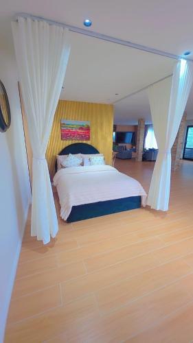 a bedroom with a bed with curtains and a wooden floor at Your Private Escape with city views in Auckland