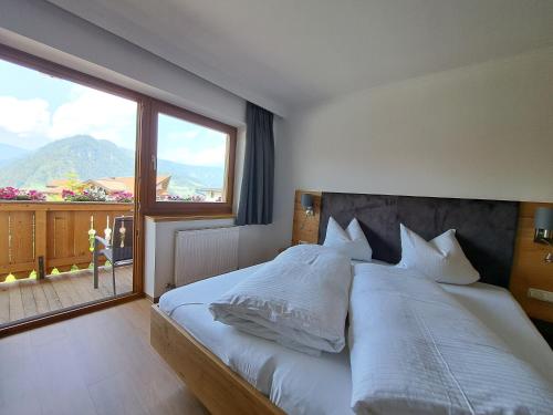 a bedroom with a large bed with a large window at Pension Edelweiß in Sankt Johann im Pongau