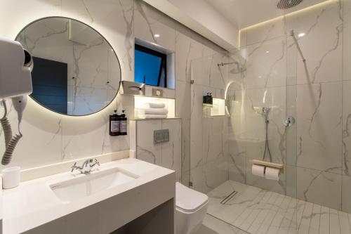 a white bathroom with a sink and a shower at The Royal Courtyard in Matatiele