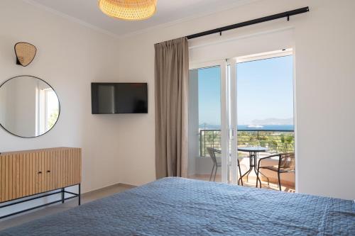 a bedroom with a bed and a view of a balcony at Thea Luxury Villa in Kos
