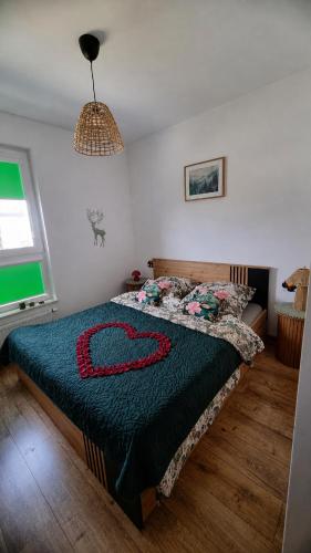 a bedroom with a bed with a blue blanket on it at Leśna Przystań Rumia - obok Gdyni i Aquaparku Reda in Rumia