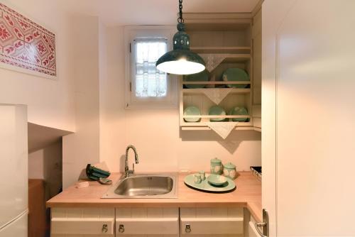 a kitchen with a sink and a light at Casa di Spetses in Spetses