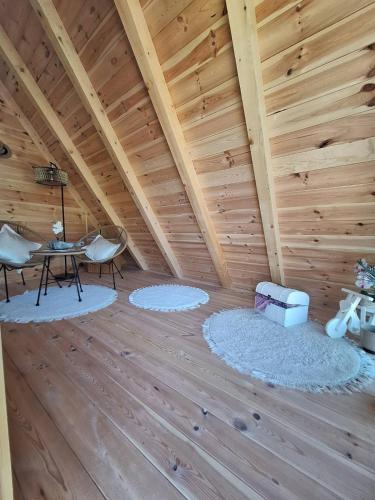 a room with a wooden ceiling with rugs on the floor at SkyFrame cottage with pool in Plav