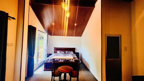 a bedroom with a bed and a table and chairs at Edinburgh Cottage's in Nanu Oya