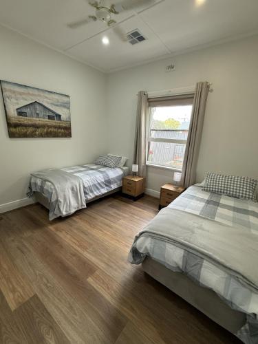 a bedroom with two beds and a window at Perrys Place in Nuriootpa