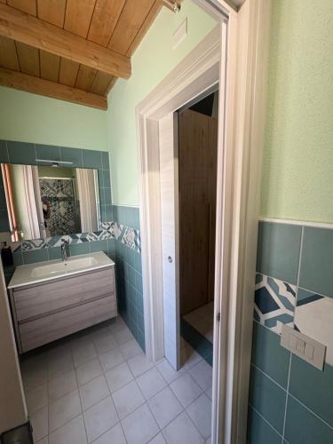 a bathroom with a tub and a sink and a mirror at La Gradinata in Gonnosfanàdiga
