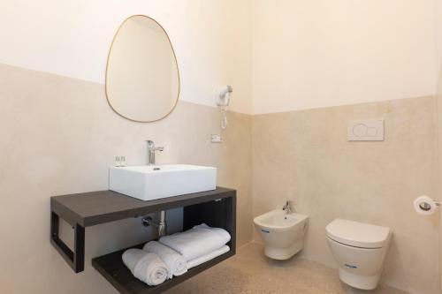 a bathroom with a sink and a toilet and a mirror at Masseria l'Ulìa in Gallipoli
