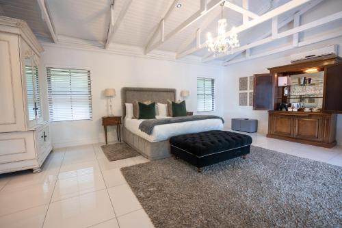 a bedroom with a king sized bed and a chandelier at Brenaissance Wine & Stud Estate in Stellenbosch