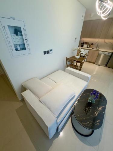 a living room with a white couch and a table at Beautiful Studio Retreat in Ras al Khaimah