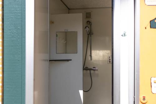 a shower in a bathroom next to a wall at Safaritent bij speeltuin voor gezinnen op groen rustig park op de Veluwe in Epe