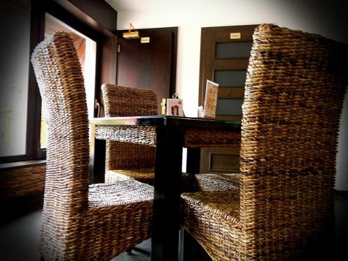 a room with a table and wicker chairs at Penzion Réva in Jablunkov