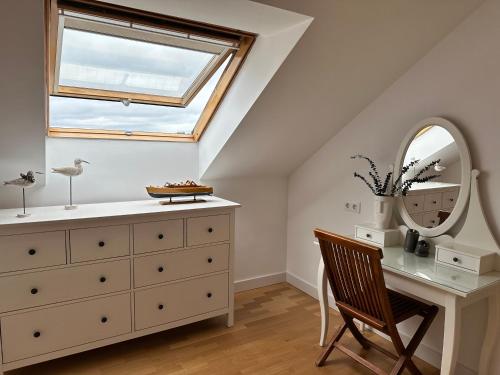 a bedroom with a dresser and a mirror and a chair at Suite Playa in Miño