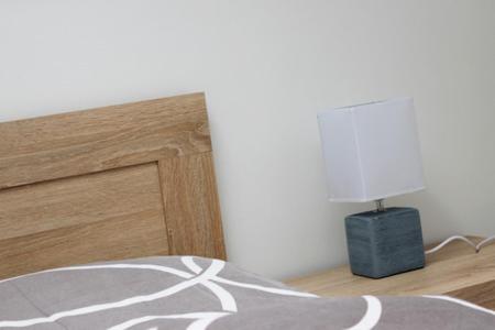 a bedroom with a bed and a lamp on the floor at Penzion Réva in Jablunkov