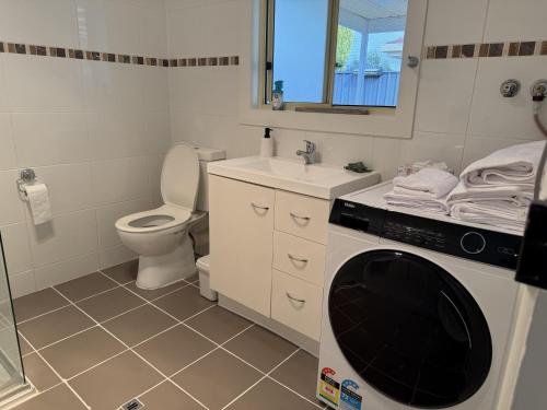 a bathroom with a toilet and a washing machine in it at Perrys Place in Nuriootpa