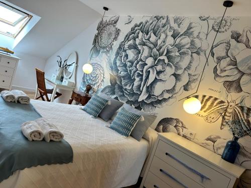 a bedroom with a bed with a flower mural on the wall at Suite Playa in Miño
