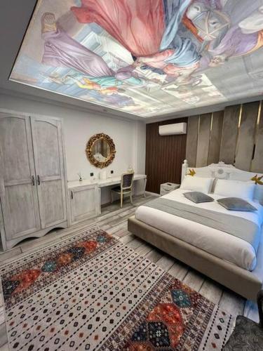 a bedroom with a large bed with a painting on the ceiling at Apera Garden in Sancaklı