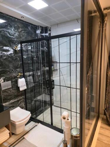 a bathroom with a toilet and a glass shower at Apera Garden in Sancaklı