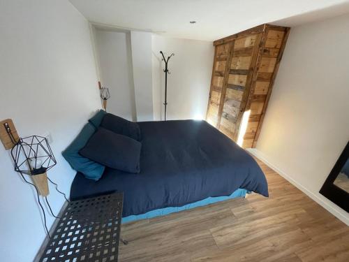 a bedroom with a bed with a blue comforter at Le balcon du Chemin des Vignes ! in Bozel