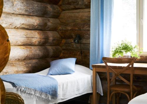 a bedroom with a wooden wall with a bed and a chair at Hawkhill Resort in Tervalampi