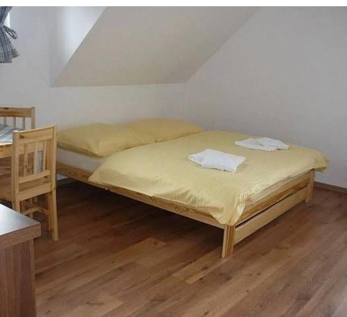 a bedroom with two beds and a wooden floor at Apartmány Na Kobylce in Modrava