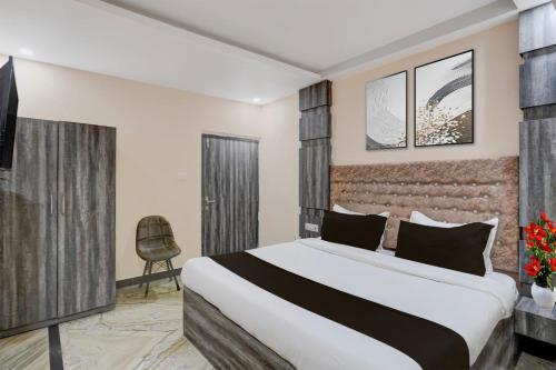a hotel room with a bed and a chair at Amba palace in Prayagraj