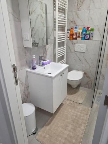 a white bathroom with a sink and a toilet at Apartman Adria Lux Doboj in Doboj