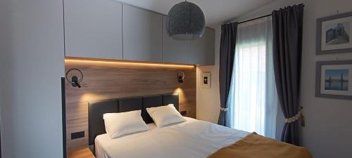 a bedroom with a bed with white sheets and a window at Rivera House Mrežnica in Generalski Stol