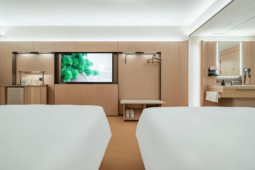 a living room with a tv and a kitchen at Ji Hotel Phnom Penh Downtown in Phnom Penh