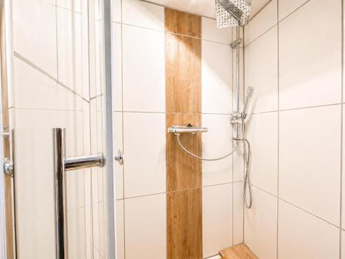 a shower in a bathroom with white tiles at Gemütlich Wohnen in Kahla bei Jena in Kahla