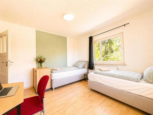 a room with two beds and a desk and a window at Gemütlich Wohnen in Kahla bei Jena in Kahla