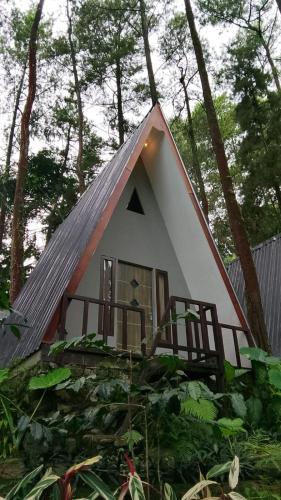 a small white house with a pitched roof at The Nest Park in Prigen