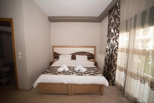 a bedroom with a bed and a window at Hotel Galaxias in Kato Loutraki