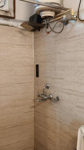 a bathroom with a metal faucet on a wall at Hotel Chandigarh Elite in Chandīgarh