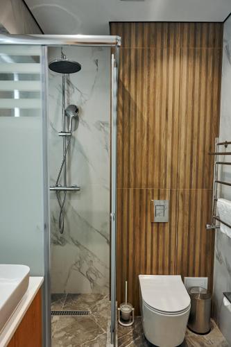 a bathroom with a shower and a toilet and a sink at Grand Altyn Hotel in Shymkent